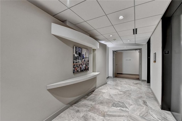 hallway featuring elevator and a drop ceiling