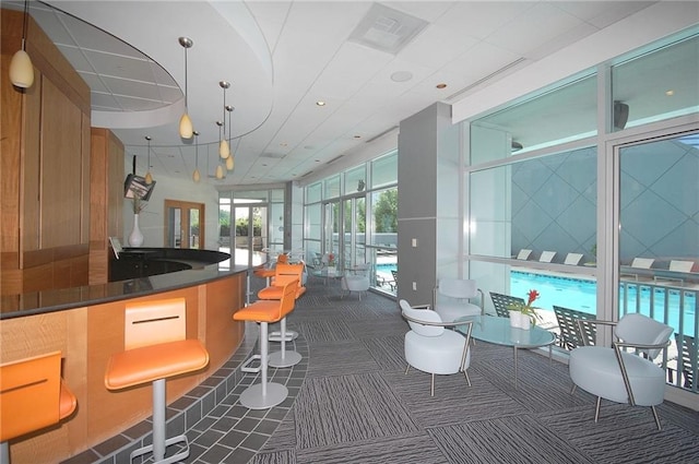 bar featuring carpet flooring and hanging light fixtures