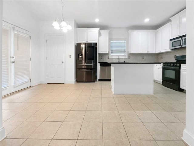 kitchen with white cabinets, stainless steel appliances, a chandelier, and light tile patterned flooring