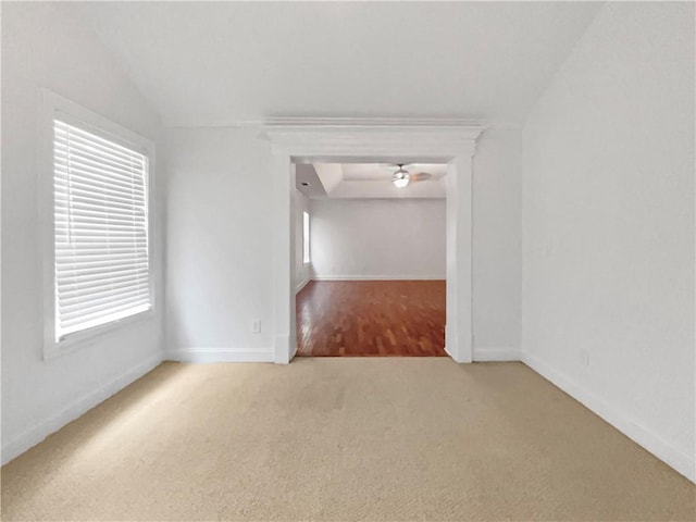 spare room featuring vaulted ceiling and carpet flooring