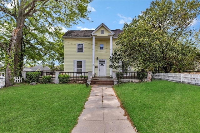 view of front facade with a wooden deck, a front yard, and fence