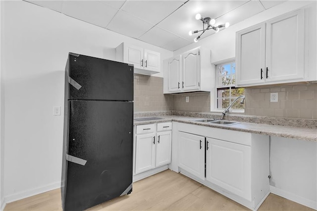 kitchen with light wood-style floors, white cabinets, light countertops, and freestanding refrigerator