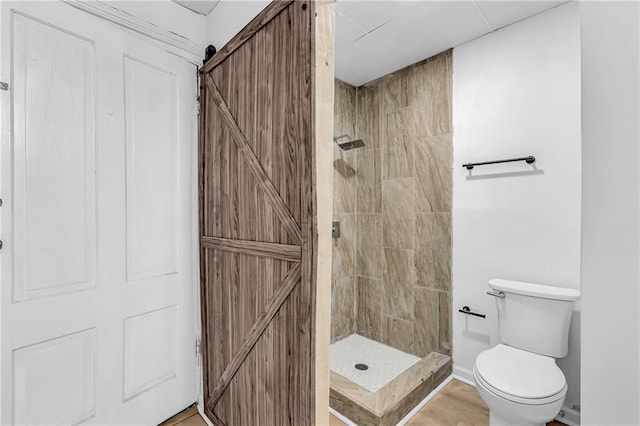 full bath featuring toilet and a tile shower