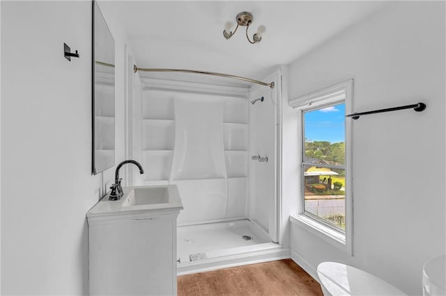 full bath featuring vanity, toilet, wood finished floors, and a stall shower