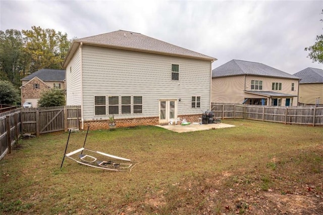 rear view of property featuring french doors, a patio, and a yard