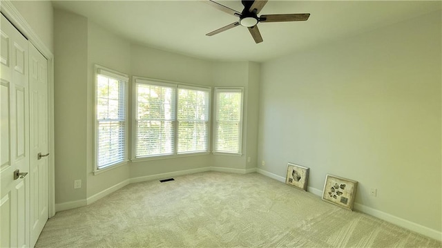 spare room featuring light carpet and ceiling fan