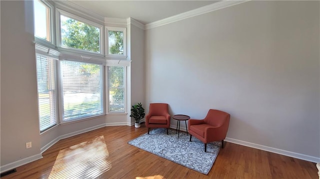 sitting room with crown molding and hardwood / wood-style flooring