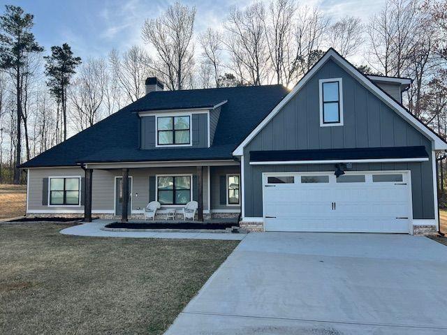 224 Crest Creek Way, Villa Rica, GA 30180 - view of front of property featuring a porch, driveway, board and batten siding, a chimney, and a front lawn