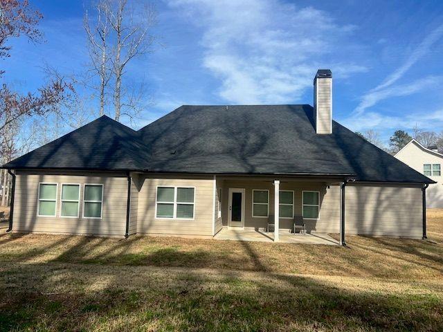 224 Crest Creek Way, Villa Rica, GA 30180 - back of house featuring a chimney, a lawn, and a patio area