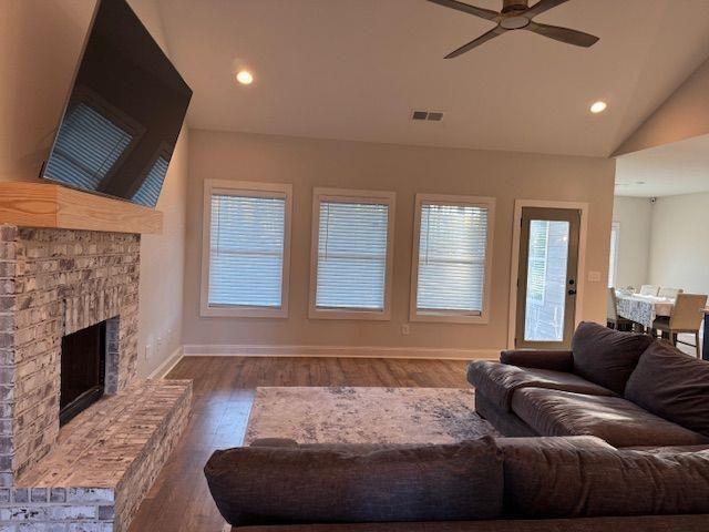 224 Crest Creek Way, Villa Rica, GA 30180 - living room with wood finished floors, ceiling fan, a brick fireplace, vaulted ceiling, and recessed lighting