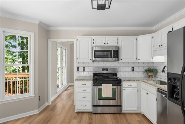 4816 Morning Chase NW, Acworth, GA 30102 - kitchen featuring appliances with stainless steel finishes, white cabinets, light stone countertops, light wood-style flooring, and crown molding