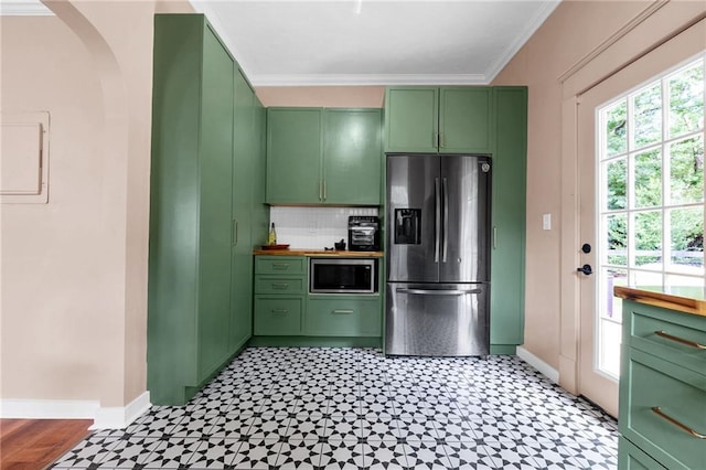 kitchen featuring stainless steel appliances, green cabinets, baseboards, and crown molding