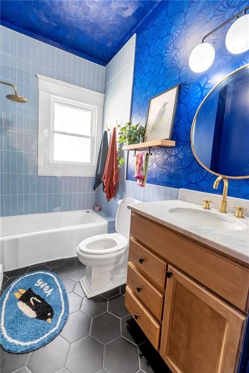 bathroom with tile patterned flooring, toilet, vanity, wallpapered walls, and shower / washtub combination
