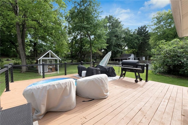 wooden terrace featuring a yard, view of scattered trees, and a grill