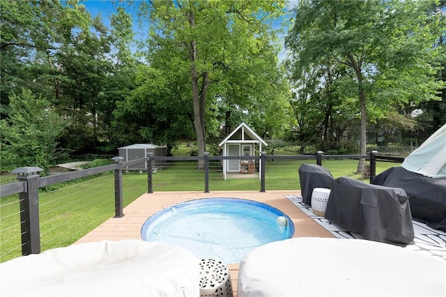 view of pool featuring a storage shed, a deck, an outbuilding, and view of wooded area