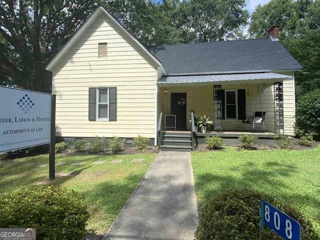 view of front facade featuring crawl space, a porch, a front yard, and a chimney