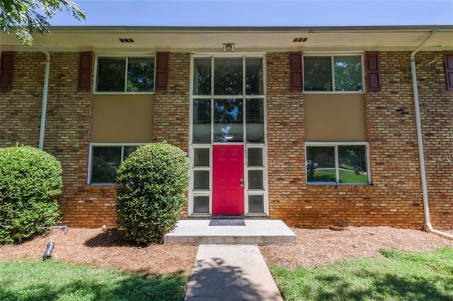 view of exterior entry with brick siding