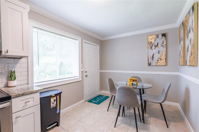 dining room with crown molding, light tile patterned floors, and baseboards