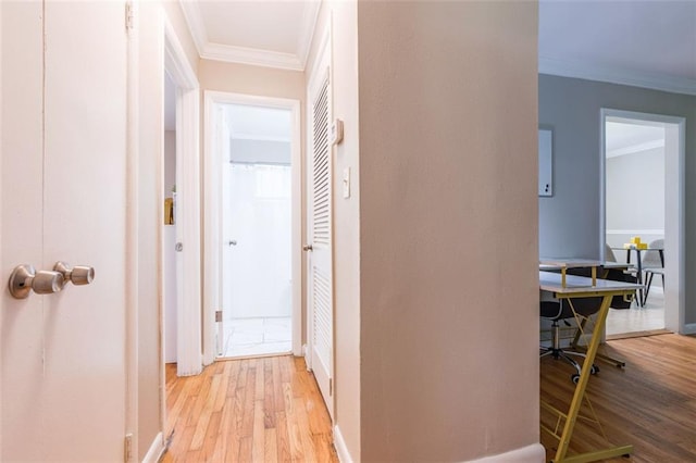 hallway featuring crown molding and light wood finished floors