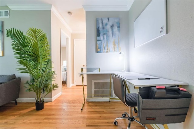 office space featuring light wood-type flooring, baseboards, visible vents, and crown molding