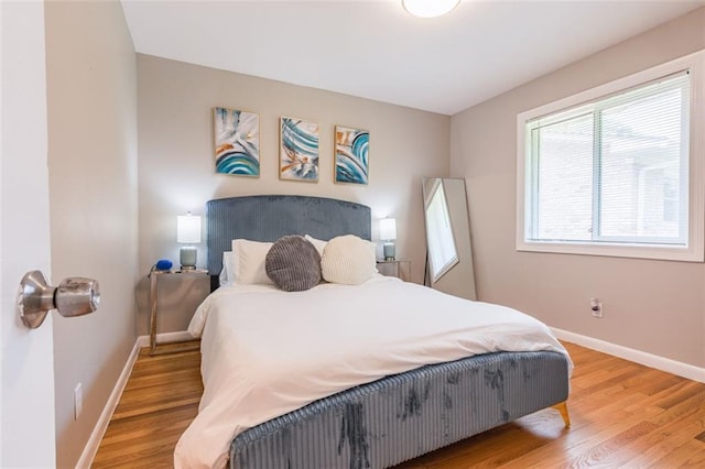 bedroom featuring baseboards and light wood-style flooring