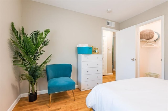 bedroom featuring visible vents, light wood-style flooring, and baseboards