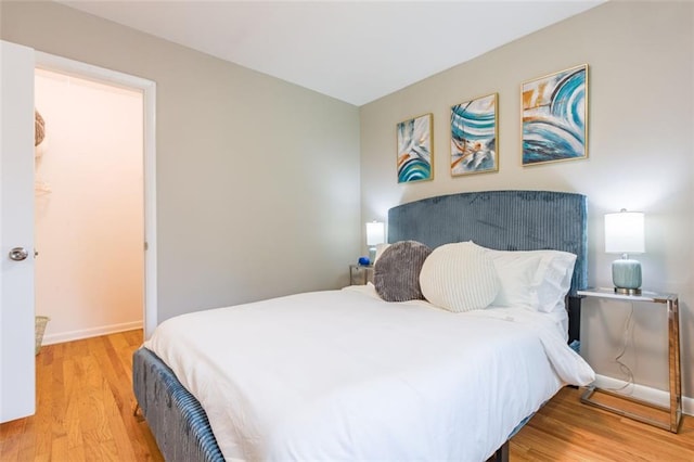 bedroom with baseboards and wood finished floors