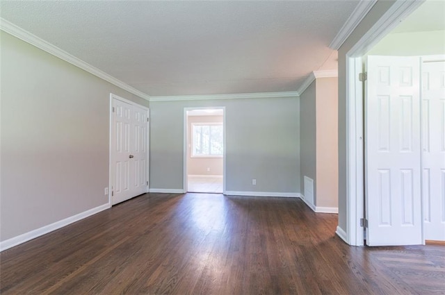 spare room featuring crown molding, baseboards, and dark wood-style flooring