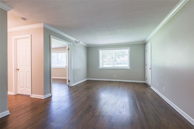 empty room with visible vents, dark wood-type flooring, ornamental molding, a textured ceiling, and baseboards