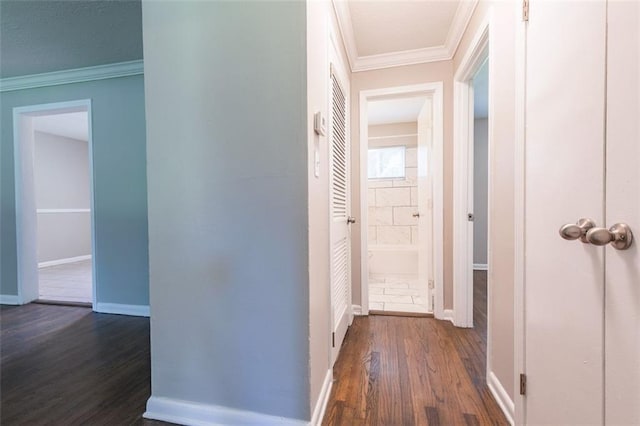 hall featuring baseboards, dark wood-type flooring, and crown molding