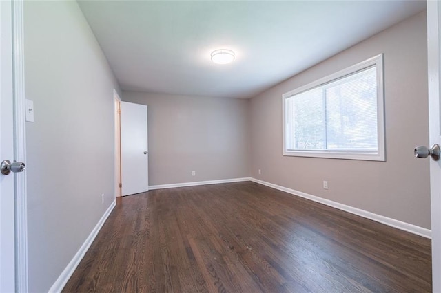 unfurnished room featuring dark wood finished floors and baseboards