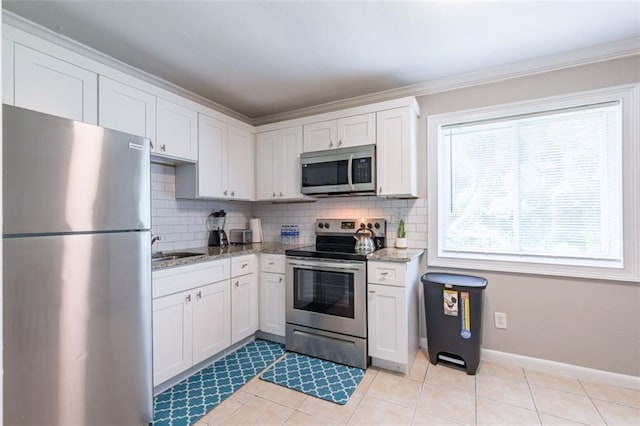 kitchen with white cabinetry, backsplash, and stainless steel appliances