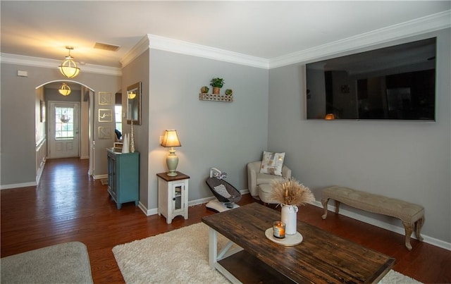 living area featuring arched walkways, ornamental molding, wood finished floors, and baseboards