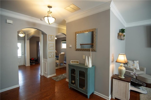 corridor with arched walkways, ornamental molding, healthy amount of natural light, dark wood-style flooring, and baseboards