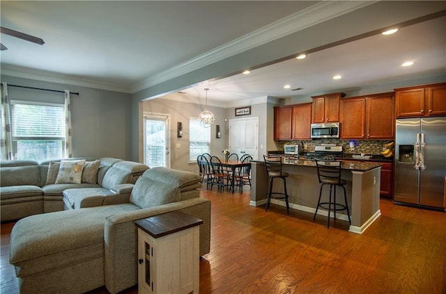 living area with a chandelier, dark wood-type flooring, ornamental molding, recessed lighting, and baseboards