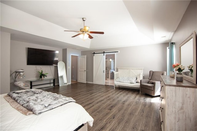 bedroom featuring a barn door, dark wood-style flooring, and ceiling fan