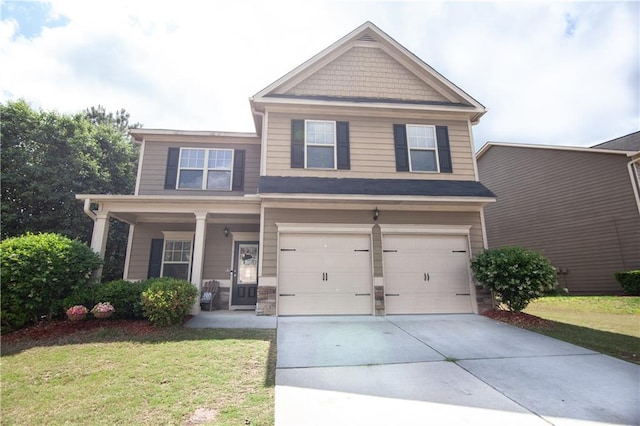 craftsman house with an attached garage, concrete driveway, a front lawn, and covered porch