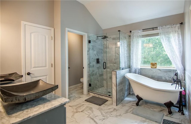 bathroom featuring a stall shower, lofted ceiling, a freestanding bath, marble finish floors, and toilet