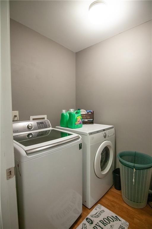 laundry room featuring separate washer and dryer and light wood-style floors