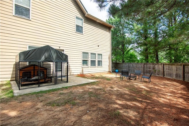 back of house featuring a fenced backyard and a fire pit
