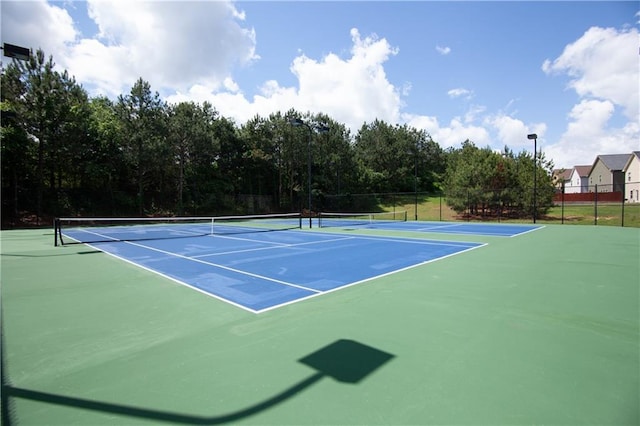 view of tennis court with fence and community basketball court