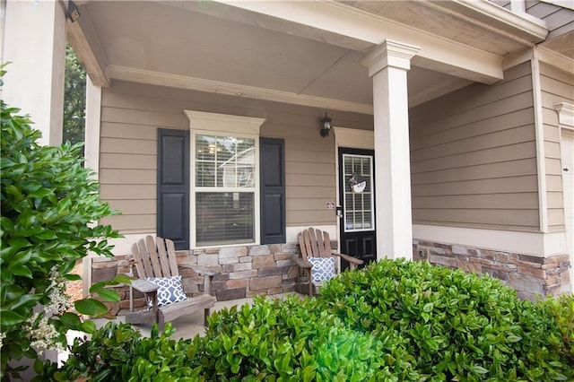 doorway to property featuring stone siding and covered porch