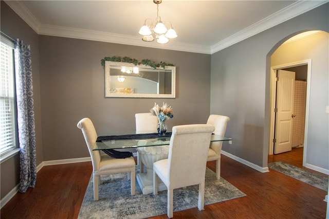 dining room featuring arched walkways, healthy amount of natural light, wood finished floors, and ornamental molding