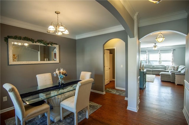 dining room with arched walkways, ornamental molding, ceiling fan, wood finished floors, and baseboards