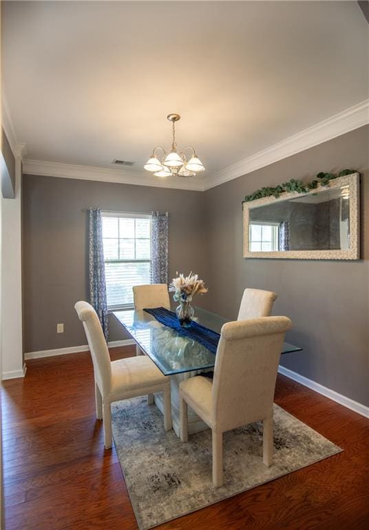 dining area featuring a chandelier, crown molding, baseboards, and dark wood-style flooring