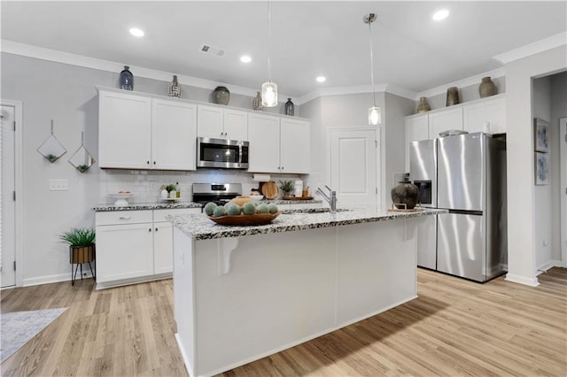 kitchen featuring a sink, white cabinets, light stone counters, and stainless steel appliances