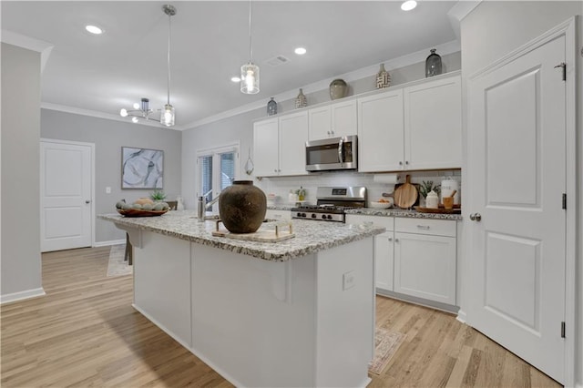 kitchen with white cabinetry, tasteful backsplash, appliances with stainless steel finishes, and ornamental molding