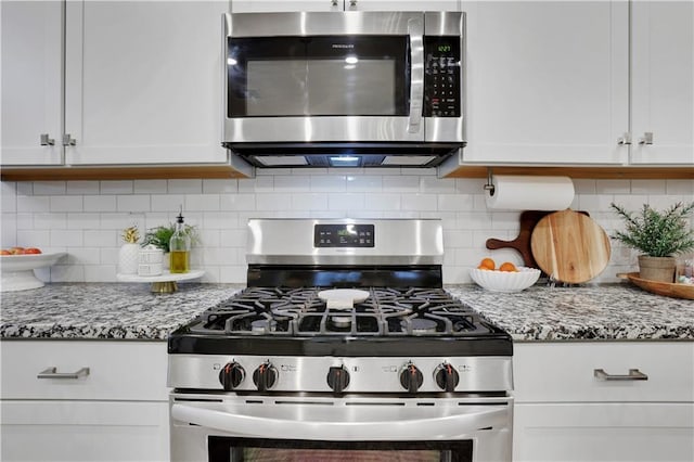 kitchen featuring tasteful backsplash, appliances with stainless steel finishes, white cabinetry, and light stone counters