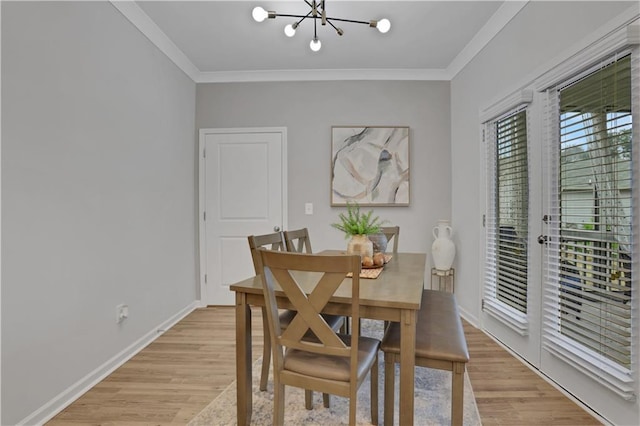 dining space featuring a notable chandelier, light wood-style flooring, baseboards, and ornamental molding