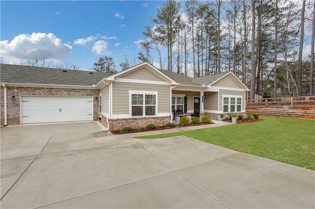 view of front facade featuring driveway, fence, a front yard, a garage, and brick siding